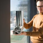 male architect engineer shows sample of double-glazed window for glazing modern glass houses