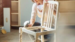 femme qui repeint une ancienne chaise